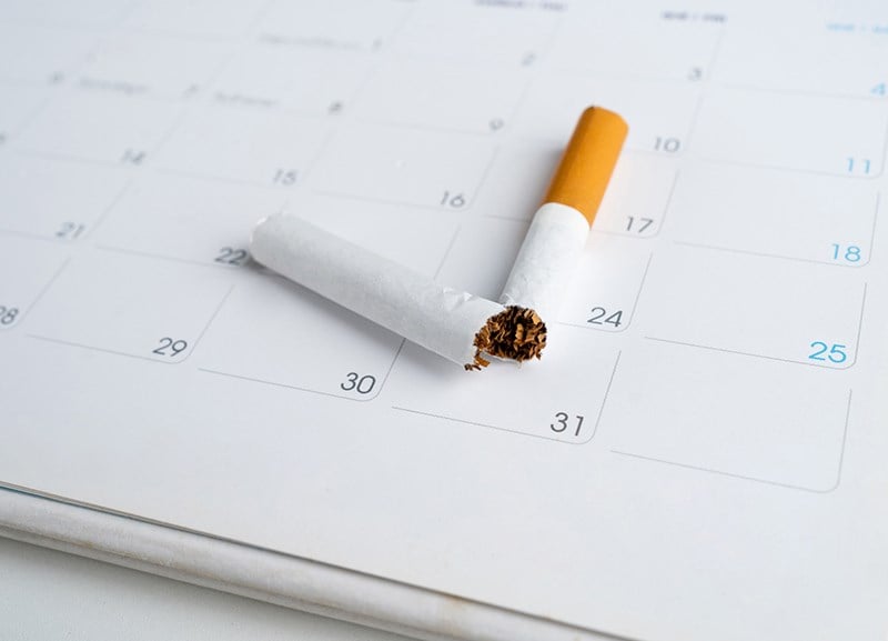En knukket sigarett ligger på en kalender